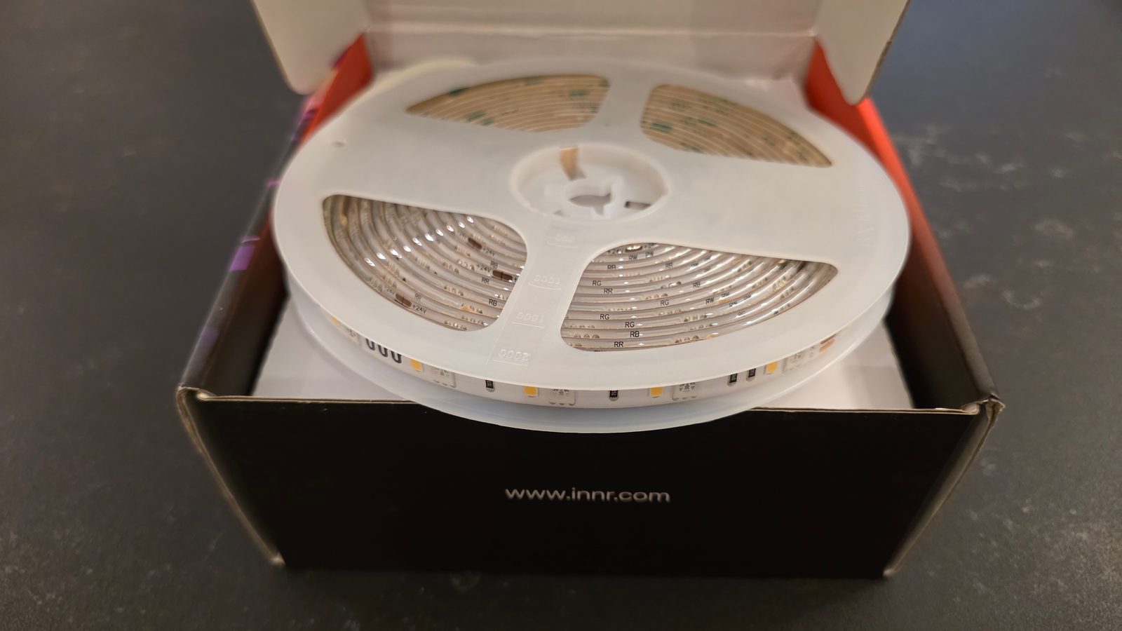 Innr FL 250 C LED strip reel sitting in its packaging box before unspooling