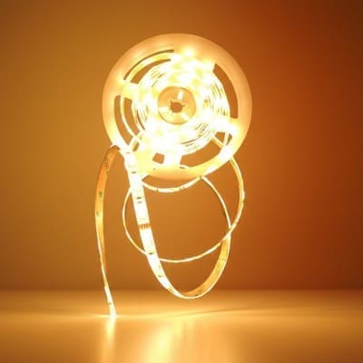 Innr FL 250 C LED strip lit in warm white, coiled on its reel